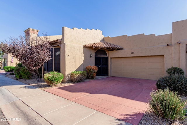 pueblo-style house featuring a garage