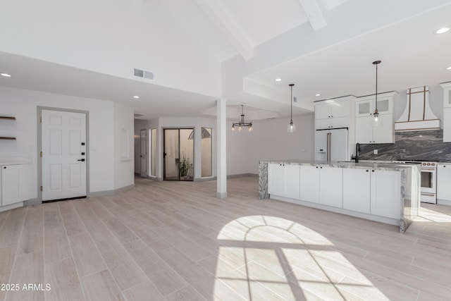 kitchen with white appliances, custom range hood, white cabinets, decorative light fixtures, and decorative backsplash