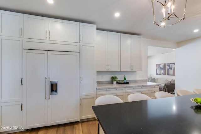 7348 N 9th Pl, Phoenix, AZ 85020 - kitchen featuring a chandelier, wood finished floors, white cabinetry, recessed lighting, and paneled built in refrigerator