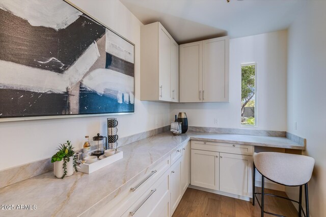 7348 N 9th Pl, Phoenix, AZ 85020 - kitchen featuring white cabinetry, wood finished floors, and light stone counters