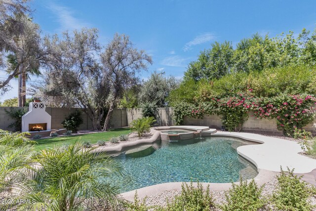 7348 N 9th Pl, Phoenix, AZ 85020 - view of pool with a warm lit fireplace, a fenced backyard, a patio, and a pool with connected hot tub