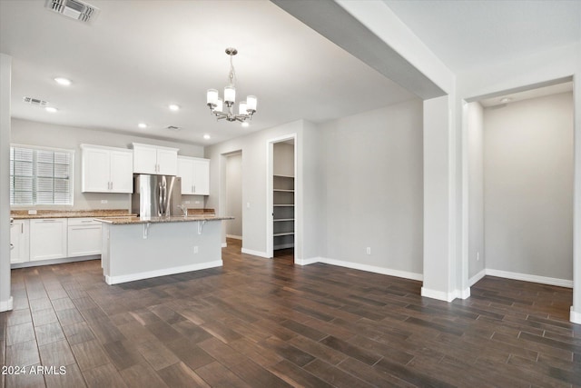 10630 W Pinchot Ave, Avondale, AZ 85392 - kitchen featuring dark wood-type flooring, stainless steel refrigerator, white cabinetry, a kitchen breakfast bar, and a kitchen island