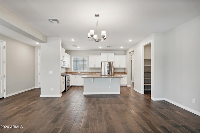 10630 W Pinchot Ave, Avondale, AZ 85392 - kitchen with appliances with stainless steel finishes, hanging light fixtures, dark hardwood / wood-style floors, white cabinets, and a kitchen island