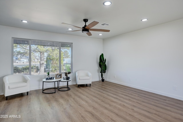 living area with ceiling fan, visible vents, recessed lighting, and wood finished floors