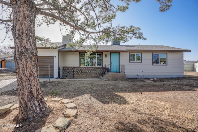 single story home with a garage, fence, and a chimney