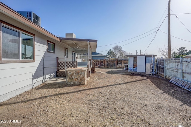 view of yard with a fenced backyard, an outbuilding, and a storage shed