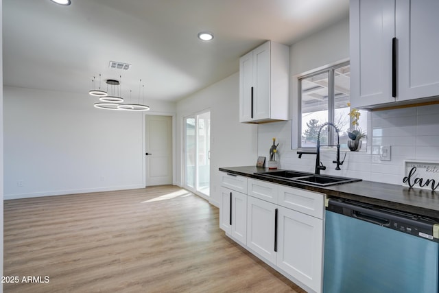 kitchen with visible vents, dark countertops, a sink, dishwashing machine, and light wood-type flooring