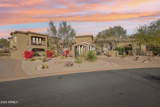 mediterranean / spanish home with a tiled roof, driveway, and stucco siding