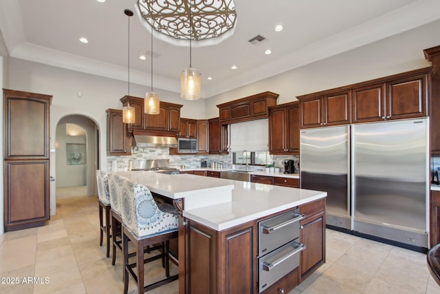 kitchen featuring arched walkways, visible vents, stainless steel appliances, and a warming drawer