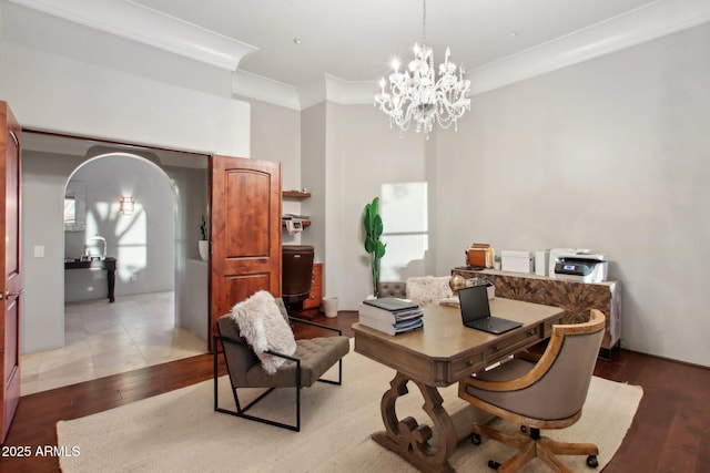 home office with arched walkways, a chandelier, crown molding, and light wood-type flooring