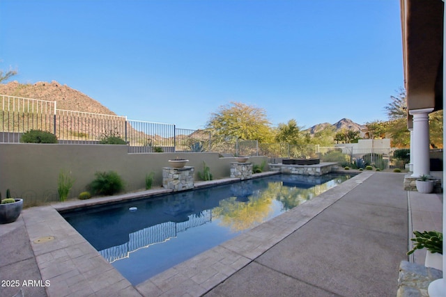 view of swimming pool featuring a mountain view, a patio, a fenced in pool, and a fenced backyard