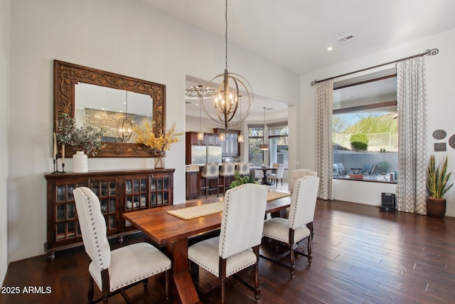 dining space with visible vents, a chandelier, and dark wood finished floors