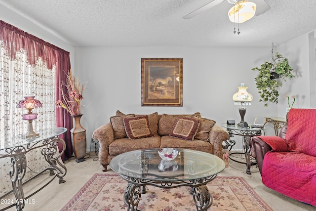 living room featuring ceiling fan, a textured ceiling, and light colored carpet