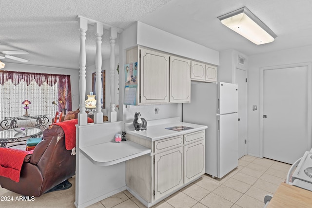 kitchen with white fridge, ceiling fan, a textured ceiling, and light tile patterned flooring