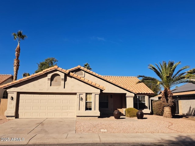 view of front of home with a garage, a tile roof, driveway, and stucco siding