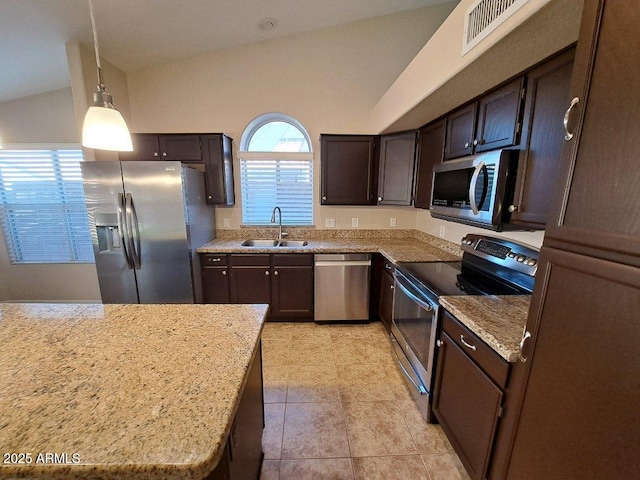 kitchen with sink, vaulted ceiling, appliances with stainless steel finishes, decorative light fixtures, and light tile patterned flooring