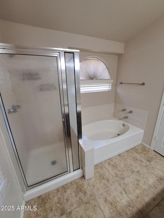 full bathroom featuring a stall shower, tile patterned flooring, and a garden tub