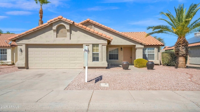 view of front of home featuring a garage, concrete driveway, a tile roof, and stucco siding