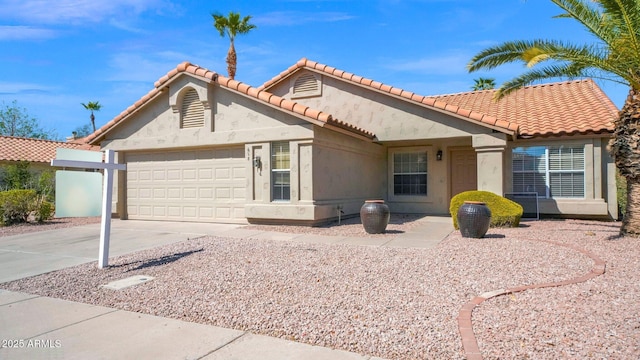 mediterranean / spanish home featuring a garage, driveway, and stucco siding