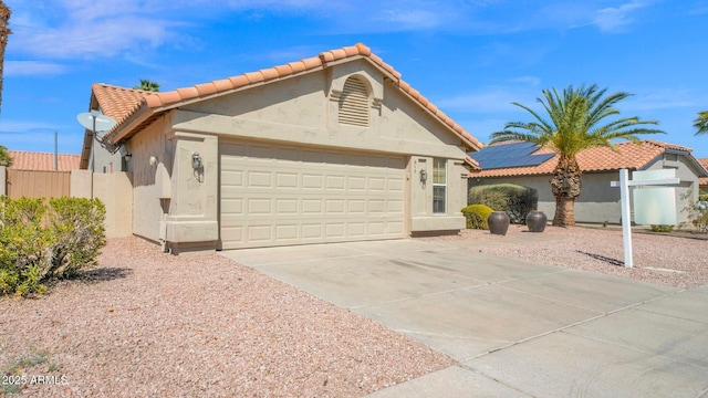 view of front of home with a garage, driveway, a tiled roof, and stucco siding