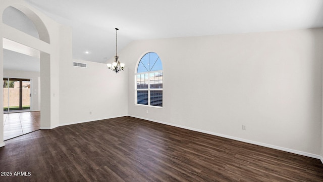 unfurnished room with an inviting chandelier, visible vents, dark wood-type flooring, and a wealth of natural light