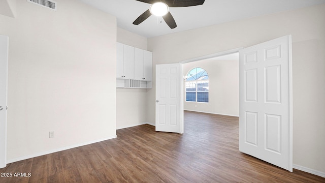 spare room featuring ceiling fan, wood finished floors, visible vents, and baseboards