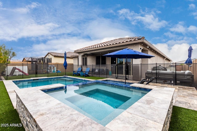 view of pool with outdoor lounge area, a patio, and an in ground hot tub