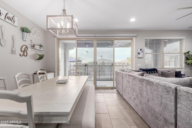 dining space with ceiling fan with notable chandelier