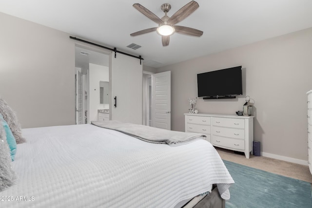 bedroom featuring ceiling fan, a barn door, and light carpet