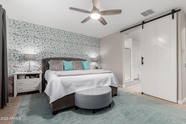 bedroom with a barn door, ceiling fan, and carpet flooring