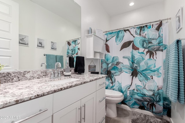 bathroom featuring vanity, curtained shower, and toilet