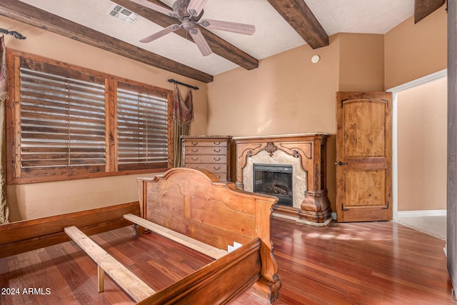 living area featuring ceiling fan, beamed ceiling, a high end fireplace, and hardwood / wood-style flooring