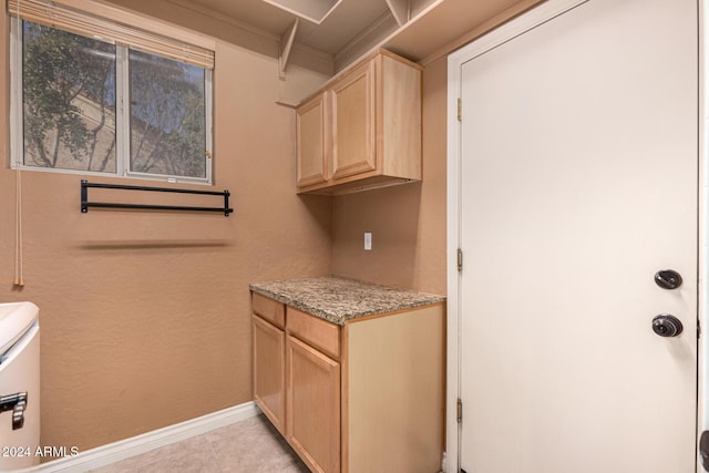 laundry area with cabinets, light tile patterned floors, and separate washer and dryer