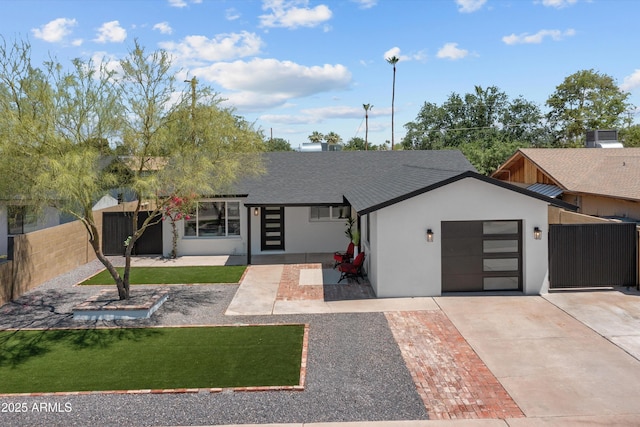 8732 E Arlington Rd, Scottsdale, AZ 85250 - view of front of house with a garage, concrete driveway, stucco siding, and roof with shingles