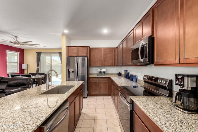 23407 W Winslow Ave, Buckeye, AZ 85326 - kitchen with appliances with stainless steel finishes, a sink, light stone counters, light tile patterned floors, and a ceiling fan