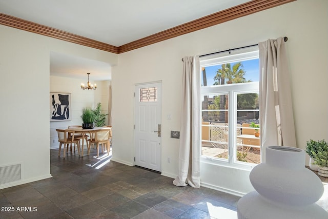 entrance foyer with crown molding, a healthy amount of sunlight, and an inviting chandelier