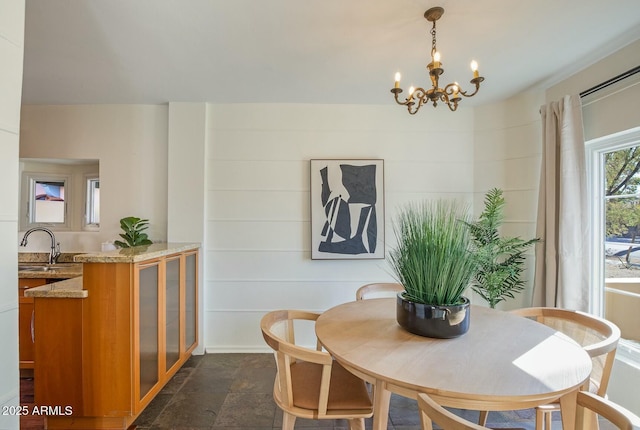 dining space featuring sink and a notable chandelier