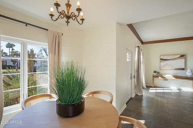 dining area with crown molding, a healthy amount of sunlight, and an inviting chandelier