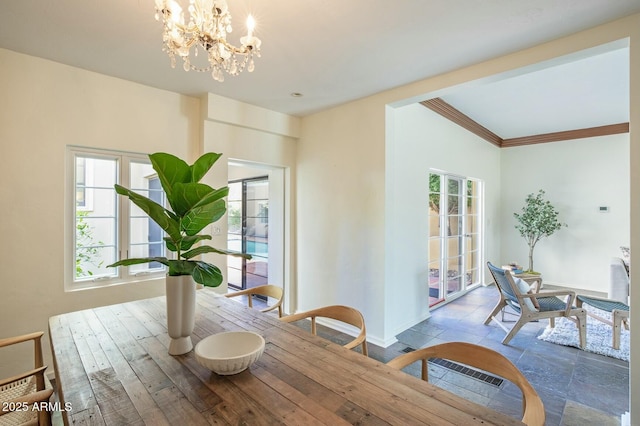 dining space featuring an inviting chandelier, ornamental molding, and plenty of natural light