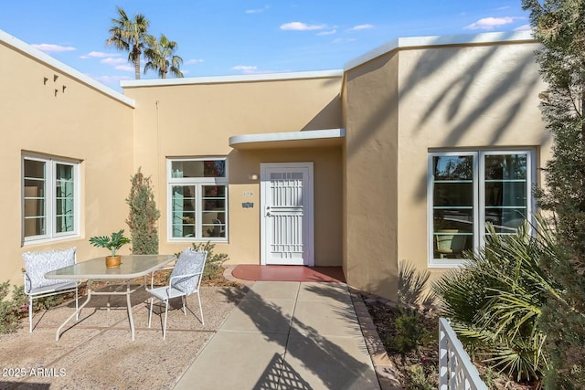 view of exterior entry with a patio