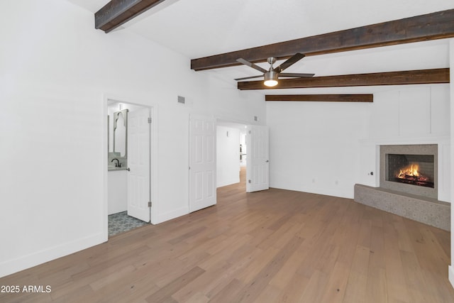 unfurnished living room with ceiling fan, lofted ceiling with beams, sink, and hardwood / wood-style flooring