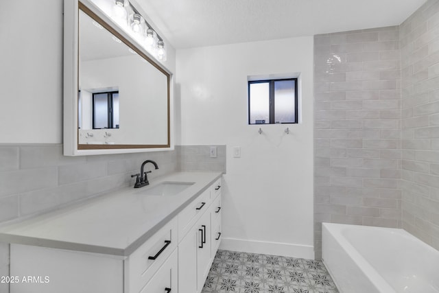 bathroom featuring a tub to relax in, vanity, and a textured ceiling