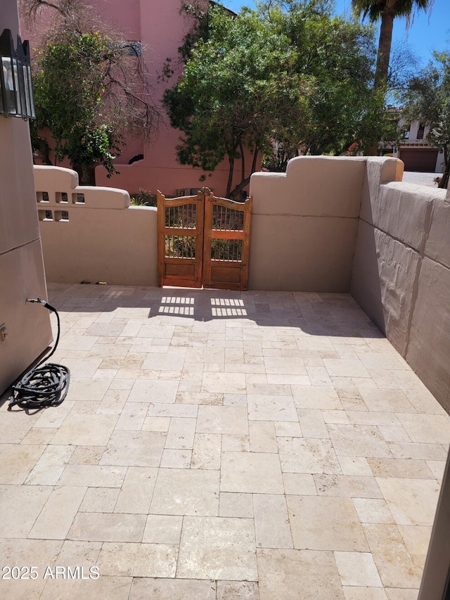 view of patio with fence and a gate