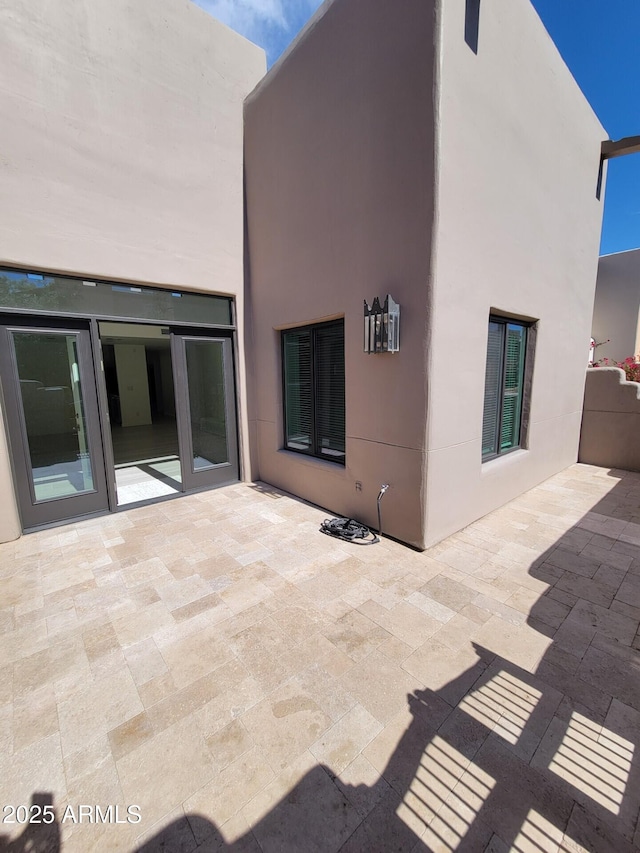 rear view of property with a patio area and stucco siding