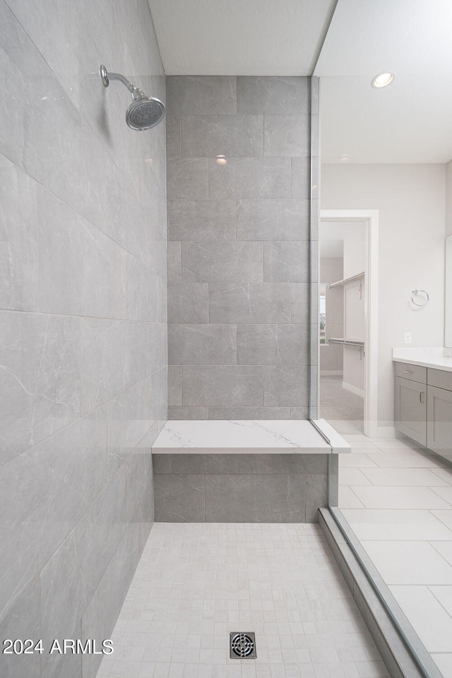 bathroom with a tile shower, tile patterned floors, and vanity