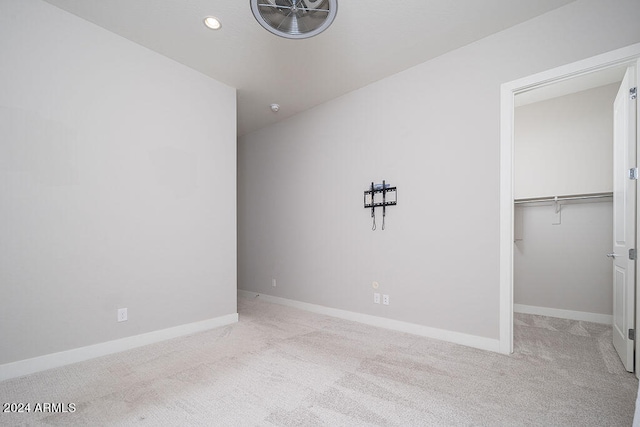 unfurnished bedroom featuring light carpet and a closet