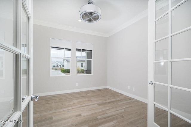 spare room with french doors, ornamental molding, and light hardwood / wood-style floors