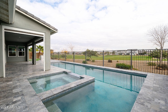 view of swimming pool featuring a patio and an in ground hot tub