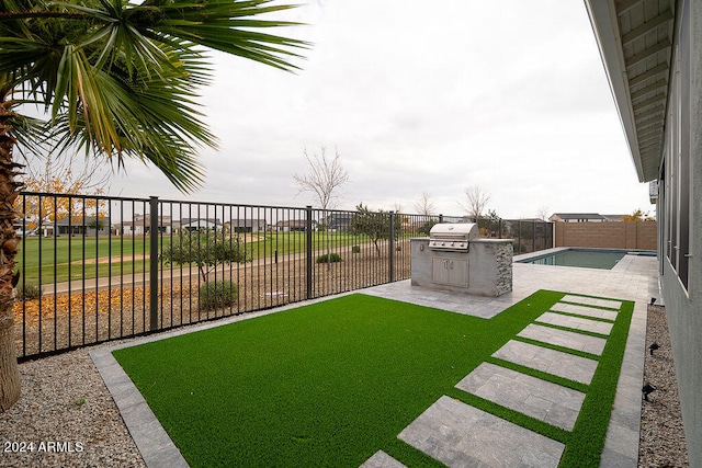 view of yard with an outdoor kitchen, a fenced in pool, and a patio area