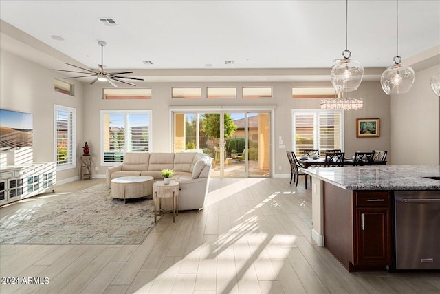 interior space with ceiling fan with notable chandelier and light hardwood / wood-style floors